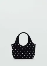 Bolso negro con lunares plateados, forro interior, doble asa corta, asa larga extraíble y cierre de imán interior.