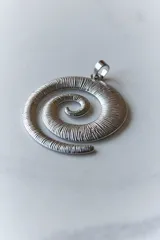 Collar con dije plateado en forma de espiral y cordón negro encerado.