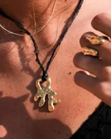 Anillo de diseño orgánico y macizo, realizado artesanalmente en bronce. Presenta una estructura abierta con dos piezas de forma irregular y textura rugosa.