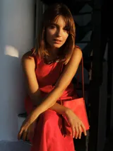 Vestido midi color crudo, de lino, con escote redondo, sin mangas y bolsillos laterales.