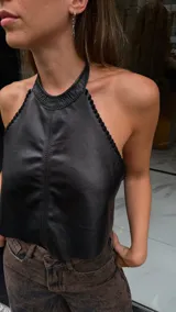 Top halter negro de efecto cuero, ajustado al cuerpo, con detalle de pespunte vertical central y borde festoneado en el escote y sisas.