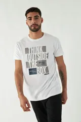 Remera color ocre de manga corta con cuello redondo y estampado frontal con texto en verde y blanco.