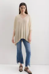 Sweater tejido de punto color crudo, con escote en V, mangas 3/4 y corte holgado.