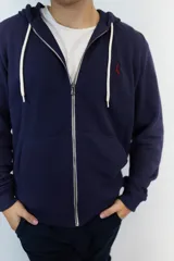 Campera con capucha color azul marino, confeccionada en algodón fino de punto, con cierre frontal y bolsillos laterales.