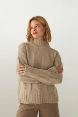 Sweater de lana color crudo, tejido de punto industrial con cuello medio.