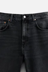 Pantalón de jean celeste con efecto lavado, corte flare fit y caída baggy desde la rodilla hasta el tobillo. Tiene cinco bolsillos y cierre frontal con botones.