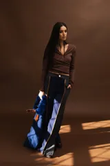 Pantalón de paño combinado con tira de cuero color marrón.