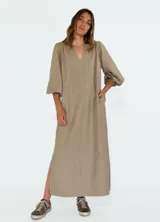 Vestido largo color beige con escote en V, mangas 3/4 abullonadas y corte holgado.