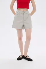 Short de jean color beige, de tiro alto y corte holgado.