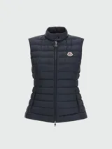 Chaleco puffer azul marino con cierre frontal y cuello alto. Presenta el logo de la marca en el pecho.