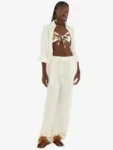 Camisa blanca texturizada de manga larga con cuello clásico y cierre frontal con botones. Confeccionada con tela ligera y puños ajustables.