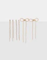 Set de tres pares de aros largos pasantes, dos con strass y uno de metal dorado.