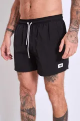 Short de baño color marrón con cordón ajustable en la cintura y logo estampado en blanco en la pierna izquierda.