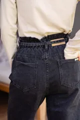 Pantalón de jean celeste de corte babucha con lazo ajustable en la cintura.