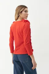 Remera color rojo con escote en V y volados laterales.