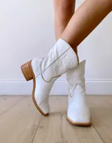Botas texanas cortas de cuero color blanco, con caña media, punta cuadrada y taco de madera.