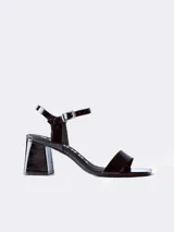 Sandalias de cuero charol negro con tira delgada sobre los dedos, pulsera con hebilla al tobillo y tacón cuadrado.