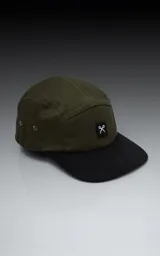 Gorra de cinco paneles color verde militar con visera negra y logo bordado en el frente.