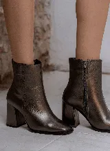 Bota corta color peltre de cuero, con taco geométrico y punta cuadrada. Presenta detalle de tachas pequeñas en el lateral y cierre con cremallera.