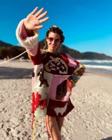 Sweater de lana tejido y bordado a mano con diseño patchwork de animales y motivos geométricos en tonos rojo, verde, marrón, beige y negro.