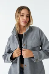 Sobrecamisa color marrón con cuello camisero, cierre frontal con botones, dos bolsillos con solapa en el pecho y corte holgado.