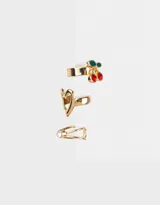 Set de tres earcuffs dorados: uno con strass, otro con forma de corazón y el tercero con dije de cereza esmaltada.