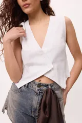 Chaleco marrón con escote en V y cierre cruzado con dos botones.