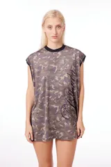 Musculosa corta de jersey con estampado camuflado en tonos verde, marrón y beige. Tiene cuello redondo negro, sisas amplias con ribete negro y estampa lateral con diseño abstracto en negro.