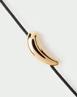 Pulsera PD Paola con cordón negro y dije dorado en forma de flecha.