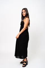 Vestido largo negro con escote en V, tirantes finos y espalda baja. Tiene frunces en la cintura que realzan la silueta.