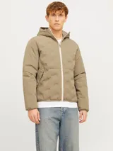 Campera híbrida color caqui, ligera e impermeable, con capucha, cierre frontal con cremallera, mangas largas con puños elásticos y bolsillos frontales con cierre.