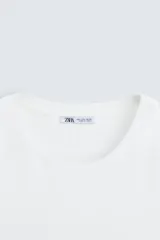 Remera color arena de corte recto, cuello redondo y mangas cortas.