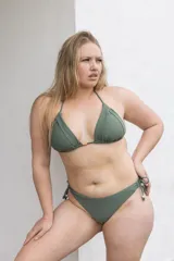 Conjunto de bikini verde militar, con corpiño triangular con detalle de frunces y accesorio dorado en el centro, y bombacha semivedetina con lazos laterales.