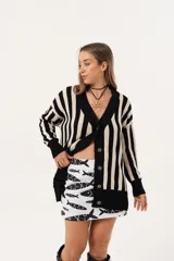 Saco oversize tejido a rayas verticales en blanco y negro, con escote en V y botones.