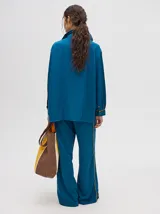 Pantalón de vestir color ladrillo, de corte holgado y tiro alto, con caída recta y detalle de diseño al costado.