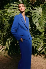 Pantalón de vestir azul eléctrico, de tiro alto, con bolsillos delanteros y falsos bolsillos de vivo en la espalda. Pierna recta con vuelta en el bajo.