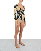 Entero de lycra color verde con estampado de flores beige, con mangas largas y escote en V con detalle de nudo.