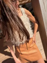 Top corto color nude dorado con textura de rafia y apliques artesanales de cuero a tono.