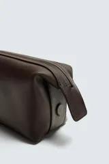 Neceser de cuero color marrón oscuro con cierre de cremallera y laterales imantados. Incluye bolsillo interior con cremallera.