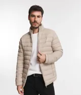 Campera puffer ultraligera color beige, con cuello alto, cierre por cremallera y bolsillos con cremallera. Incluye bolso de almacenamiento.