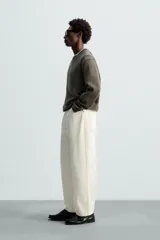 Pantalón de jean negro de corte amplio y tiro alto, con cinco bolsillos y cierre frontal con botón.