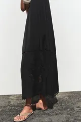 Vestido midi negro de tirantes finos con escote recto y detalle de bordados perforados a tono.