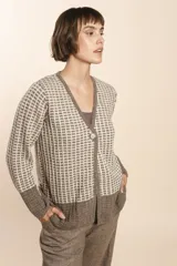 Cardigan tejido con efecto fantasia color crema. Una prenda de silueta amplia y cómoda. Tejido en 100% lana fina sin teñir.