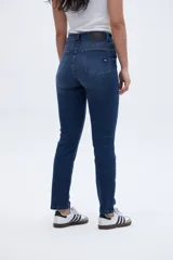 Jean de tiro medio color azul oscuro, de calce ajustado desde la cintura hasta los tobillos.