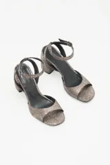 Sandalias de cuero color peltre con textura craquelada, tira delantera y tobillera con hebilla metálica. Taco cuadrado.