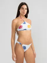 Top de bikini con estampado de flores y rayas verticales, estilo halter con tiras finas y charm floral en el centro.