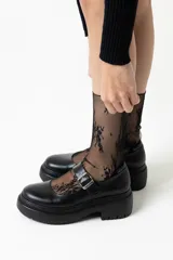 Mocasines negros de cuero con hebilla plateada y suela track.