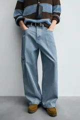 Pantalón de jean celeste de corte holgado y amplio en toda la pierna, tiro medio, tejido rígido, cinco bolsillos, efecto lavado, parche en trasero y bolsillo de vivo en pernera.