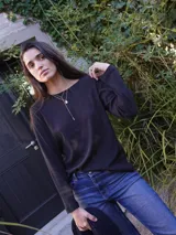Remera negra de manga larga con cuello redondo y logo bordado en el pecho.