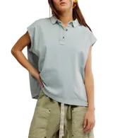 Remera estilo polo blanca de corte amplio con cuello clásico y botonadura corta en el frente. Tiene mangas cortas con dobladillo y aberturas laterales en el ruedo.